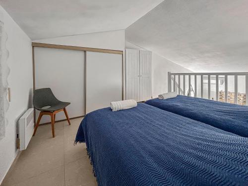 - une chambre avec un lit bleu et une chaise dans l'établissement Vue Mer, Piscine, Terrasse Privée et Clim, à Cavalaire-sur-Mer
