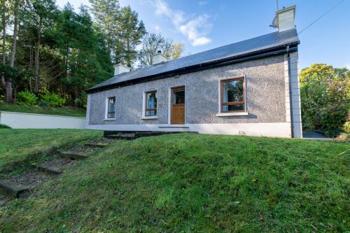 a house with a grassy yard in front of it at Herbie's Cottage in Letterkenny