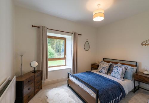 a bedroom with a bed and a window at Herbie's Cottage in Letterkenny