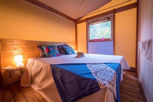 圣于连－德朗德Camping Château La Forêt的一间带床的卧室，位于一间有窗户的房间里