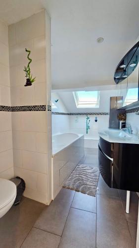 une salle de bain avec une baignoire, des toilettes et un lavabo dans l'établissement Chambre privée dans logement partagé, Pinky Elisabeth cozy Paris & Stade de France, à Stains