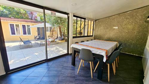 une salle à manger avec une table et des chaises ainsi qu'une terrasse dans l'établissement Chambre privée dans logement partagé, Pinky Elisabeth cozy Paris & Stade de France, à Stains