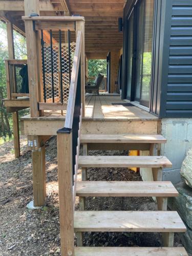 a wooden staircase leading to a porch of a house at Treetop Suite in Haliburton