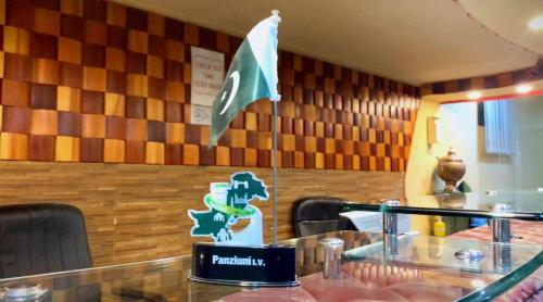 a flag on the wall of a restaurant with a table at Hotel City View Peshawar in Peshawar