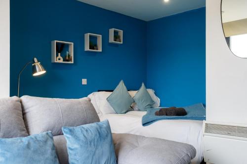 a blue room with a bed and a couch at Cozy Studio Apartment in Sheffield in Sheffield