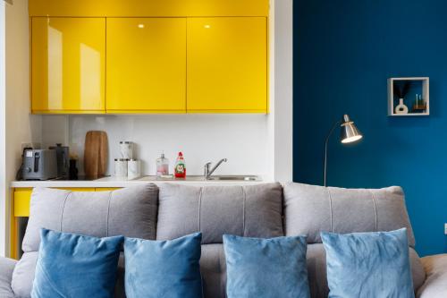 a living room with a couch and yellow cabinets at Cozy Studio Apartment in Sheffield in Sheffield