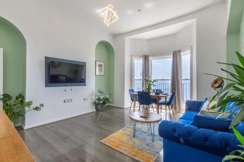 a living room with a blue couch and a table at Sea Breeze - 1 bedroom flat in Brighton & Hove