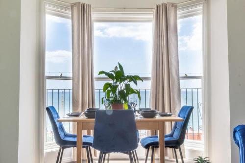 a dining room with a table and chairs and a large window at Sea Breeze - 1 bedroom flat in Brighton & Hove