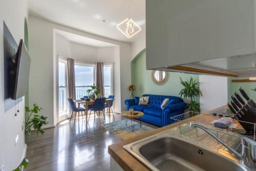a kitchen and living room with a blue couch at Sea Breeze - 1 bedroom flat in Brighton & Hove