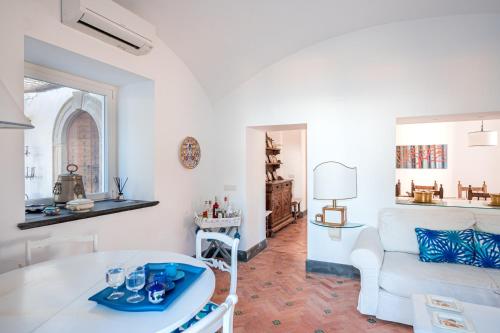 Villa Serao Cottage Camilla by MyVillaCollection في ايسكيا: غرفة معيشة مع أريكة بيضاء وطاولة