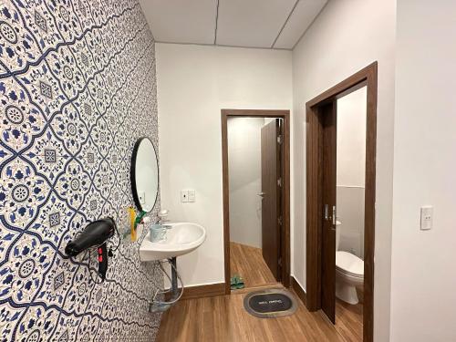 a bathroom with a sink and a mirror on a wall at Gạoo Gạo Homestay in Thôn Dương Phẩm