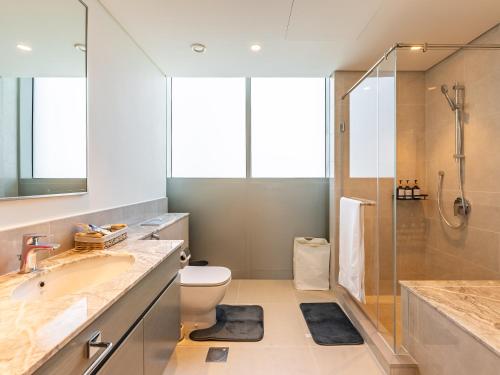 a bathroom with a sink and a toilet and a shower at the London Condo - Forte Downtown Dubai in Dubai
