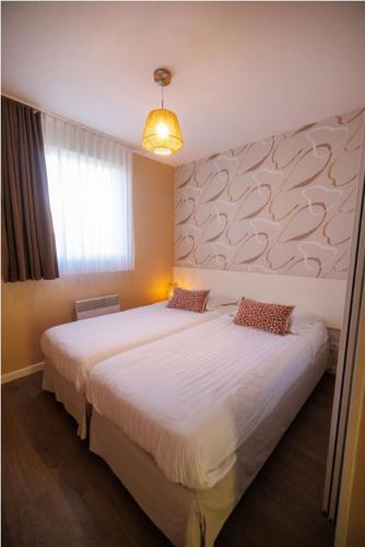 a bedroom with two beds and a window at Résidence Les Rives de la Fecht - Colmar Ouest in Ingersheim