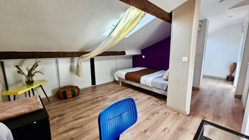 une chambre avec un lit et une chaise bleue dans l'établissement Chambre privée dans logement partagé, Serenity cozy Paris & Stade de France, à Stains