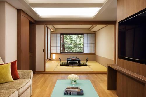 a living room with a couch and a tv at Karuizawa Marriott Hotel in Karuizawa