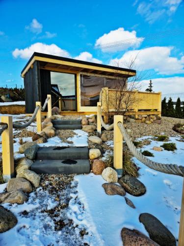 a log cabin in the snow with a stone path at Czôrny Dąb - nowoczesny dom wakacyjny na Kaszubach, jacuzzi, sauna, bilard in Garcz