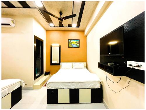 a bedroom with a bed and a flat screen tv at Hotel Pragati Heights in Mathura
