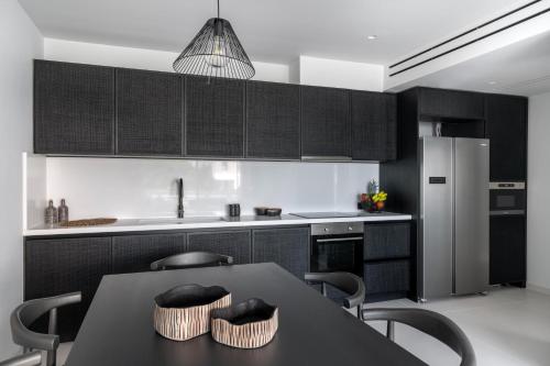 a kitchen with black cabinets and a table with chairs at Marina Suite in Porto Heli