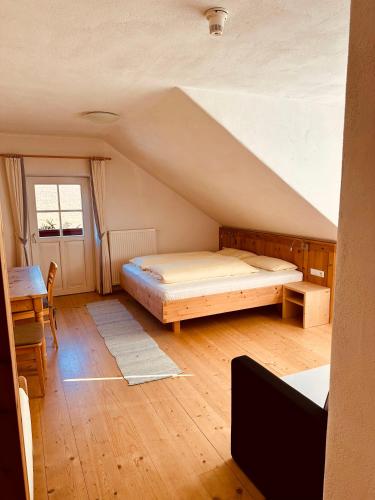 a bedroom with a bed and a desk in a attic at Oberraut in Brunico