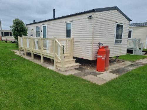 a house with a fire hydrant in front of it at S212 6 BERTH DELUXE GOLDEN PALM CHAPEL ST LEONARDs in Chapel Saint Leonards