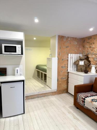 un salon avec un canapé et une cuisine dans l'établissement Appartement entre mer et montagne, à Gréolières