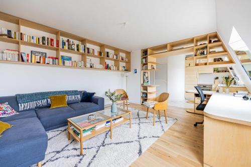 un salon avec un canapé bleu et une table dans l'établissement Appartement Compiègne - Welkeys, à Paris