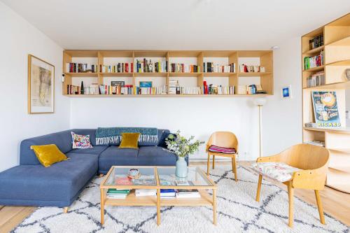 un salon avec un canapé bleu et une table dans l'établissement Appartement Compiègne - Welkeys, à Paris
