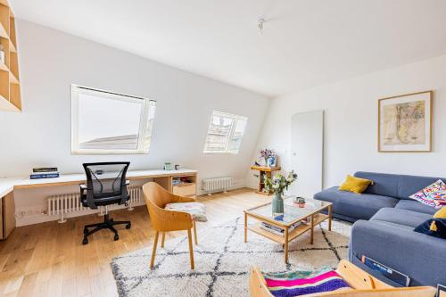 - un salon avec un canapé bleu et un bureau dans l'établissement Appartement Compiègne - Welkeys, à Paris