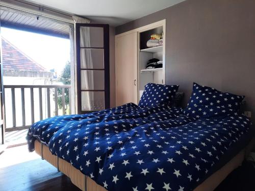- un lit avec une couette bleue et des étoiles blanches dans l'établissement Happy Days 2, à Beaulieu-sur-Dordogne