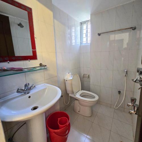 a white bathroom with a sink and a toilet at Falcon Beach Resort in Cox's Bazar