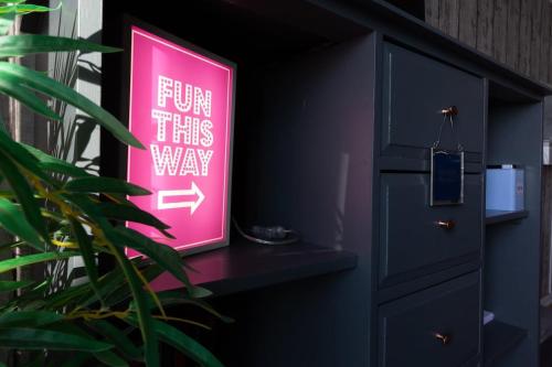 a pink sign sitting on a shelf next to a plant at Harbour Hideaway - Free Parking in Brighton & Hove