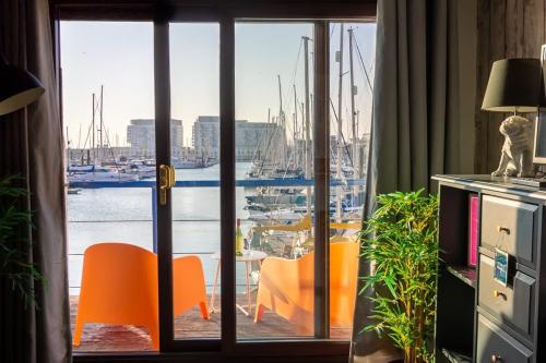 a room with a view of a marina with orange chairs at Harbour Hideaway - Free Parking in Brighton & Hove