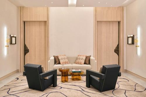 a living room with a couch and two chairs at Hotel Arts Barcelona in Barcelona