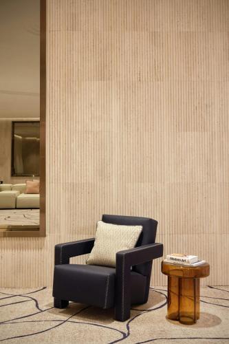 a living room with a chair and a table at Hotel Arts Barcelona in Barcelona