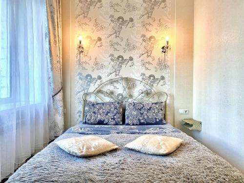 a bedroom with a bed with two pillows on it at ApartPoltava Елегантна ДВОКІМНАТНА студія з панорамою на театр Гоголя, ЦУМ, Фіскальний ЧЕК in Poltava