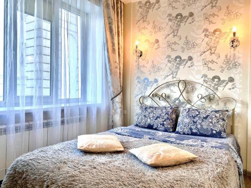 a bedroom with a bed with two pillows on it at ApartPoltava Елегантна ДВОКІМНАТНА студія з панорамою на театр Гоголя, ЦУМ, Фіскальний ЧЕК in Poltava
