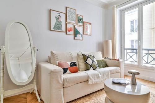 un salon avec un canapé et un miroir dans l'établissement Paris à Pied : Folies Bergère et Grands Boulevards, à Paris