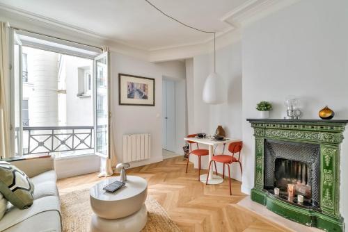 - un salon avec une cheminée verte et une table dans l'établissement Paris à Pied : Folies Bergère et Grands Boulevards, à Paris