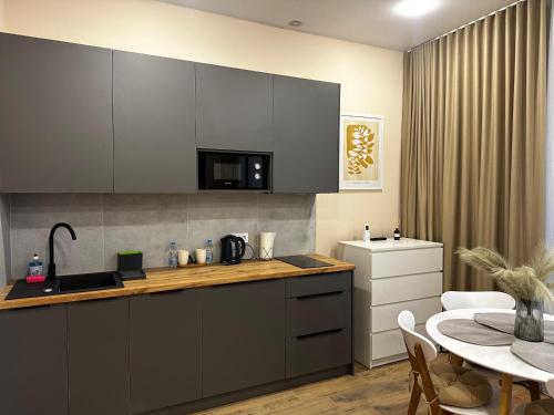 a kitchen with a counter top and a table and a table and a dining room at Smart House Apartments in Lviv