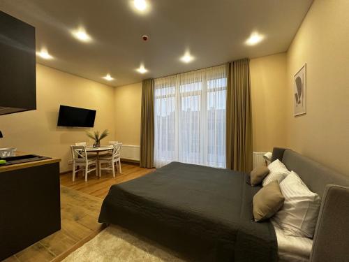 a bedroom with a bed and a table and a television at Smart House Apartments in Lviv