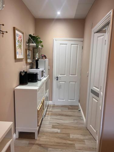 a kitchen with a white door and a microwave at Lawson Lodge in Alveston