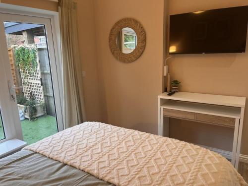 Un dormitorio con una cama y un televisor de pantalla plana. en Lawson Lodge, en Alveston