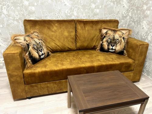 two lions sitting on a couch in a living room at An apartment by the Emajõgi River in Tartu