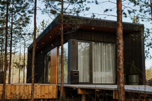 a house in the woods with a large window at ForRest Glamp Saulkrasti in Saulkrasti