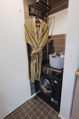 a laundry room with a washing machine and a towel at ForRest Glamp Saulkrasti in Saulkrasti