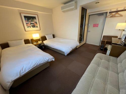 a hotel room with two beds and a desk at リオンドール in Kyoto