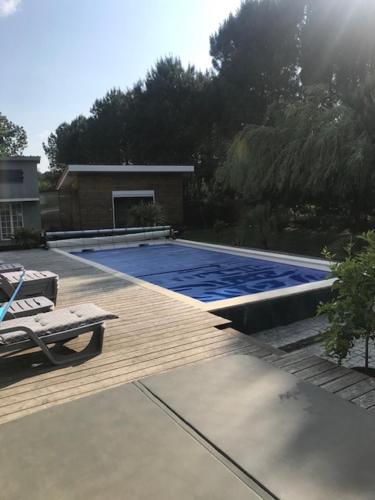 - une piscine sur une terrasse en bois avec une chaise dans l'établissement Domaine Papillon, à Talais
