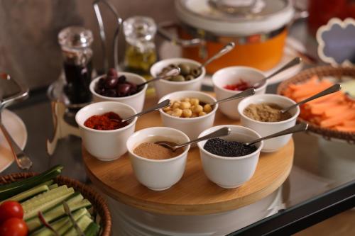 a table topped with bowls of different types of food at The Biltmore Hotel Villas, Dubai in Dubai