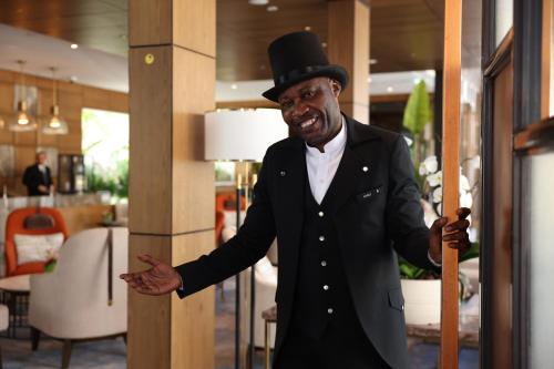 a man wearing a top hat holding a cane at The Biltmore Hotel Villas, Dubai in Dubai