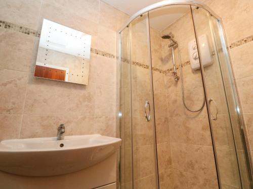 un baño con lavabo y ducha en Mousehole Bungalow, en Penzance